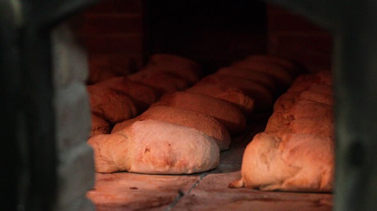 Loaves Of Bread Being Cooked Inside The Traditional Oven In The Bakery.