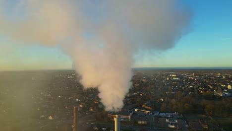 smoke emission from industrial factory chimney at sunrise