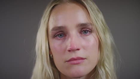 emocional joven mujer rubia mirando a la cámara