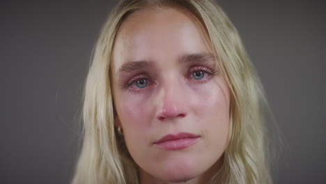 emotional young blonde woman looking at camera