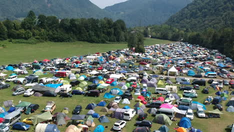 aerial drone shot of a camping ground at a music festival in a green and lush mountainous area