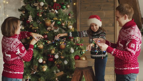 familia feliz poniendo luces en el árbol de navidad en casa