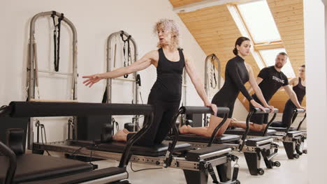 clase de reformador de pilates con adultos mayores e instructores