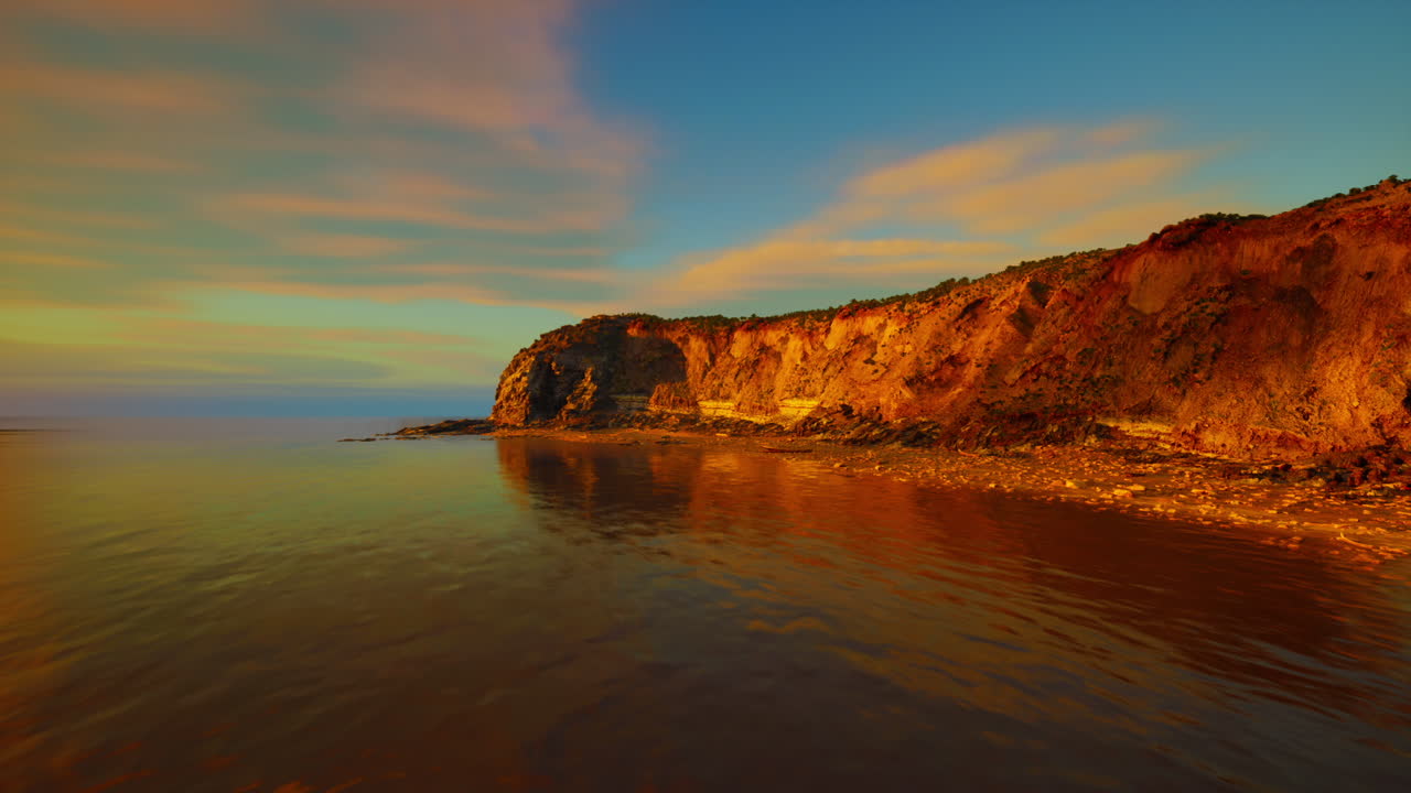 Tramonto drammatico su scogliere rocciose, che illumina le rocce frastagliate.