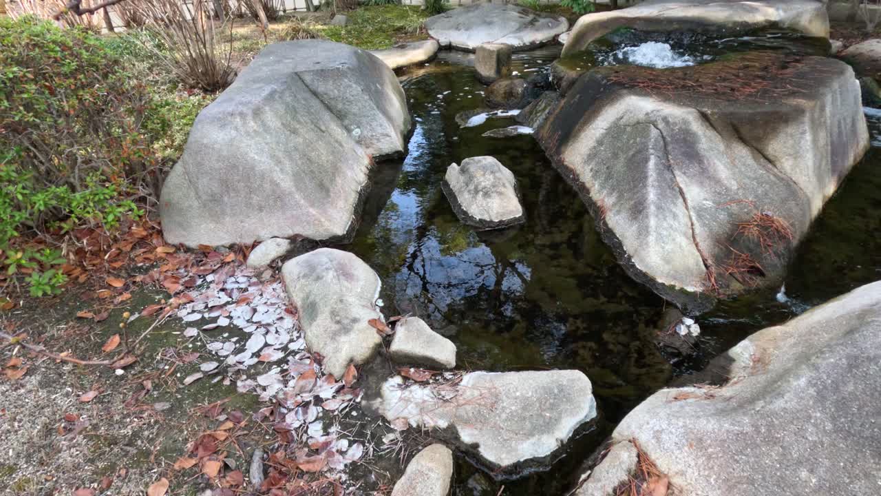 물은 조용한 환경에서 돌 위에 부드럽게 폭포로 떨어집니다.