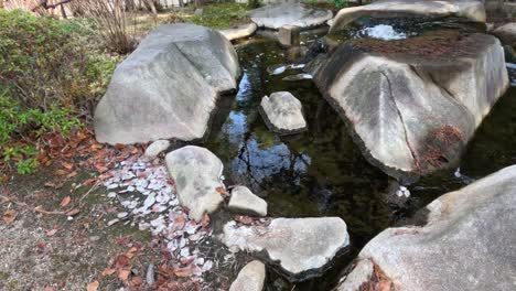 water gently cascades over stones in a serene setting