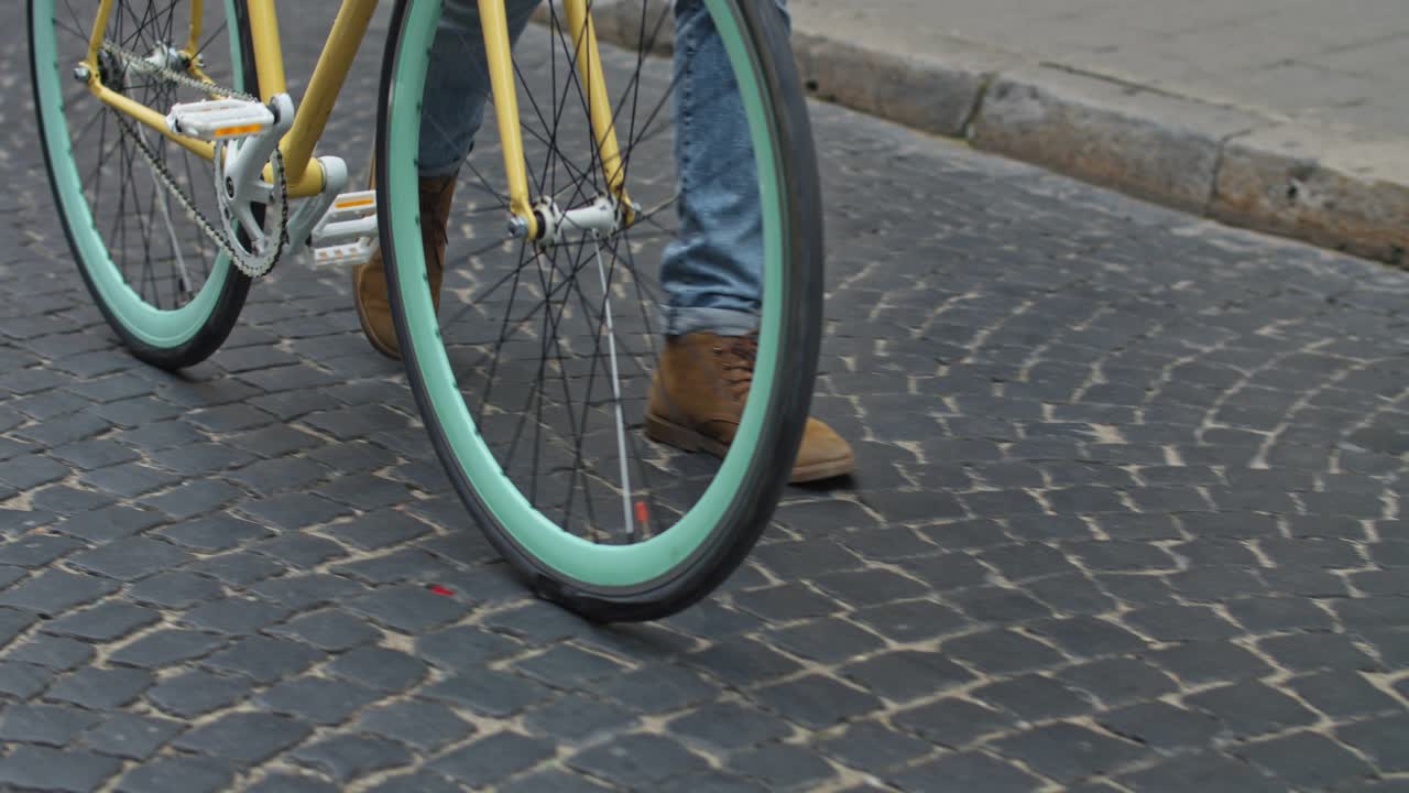 Person with a bicycle on a cobblestone street