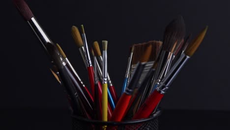 front view of a container full of painting brushes