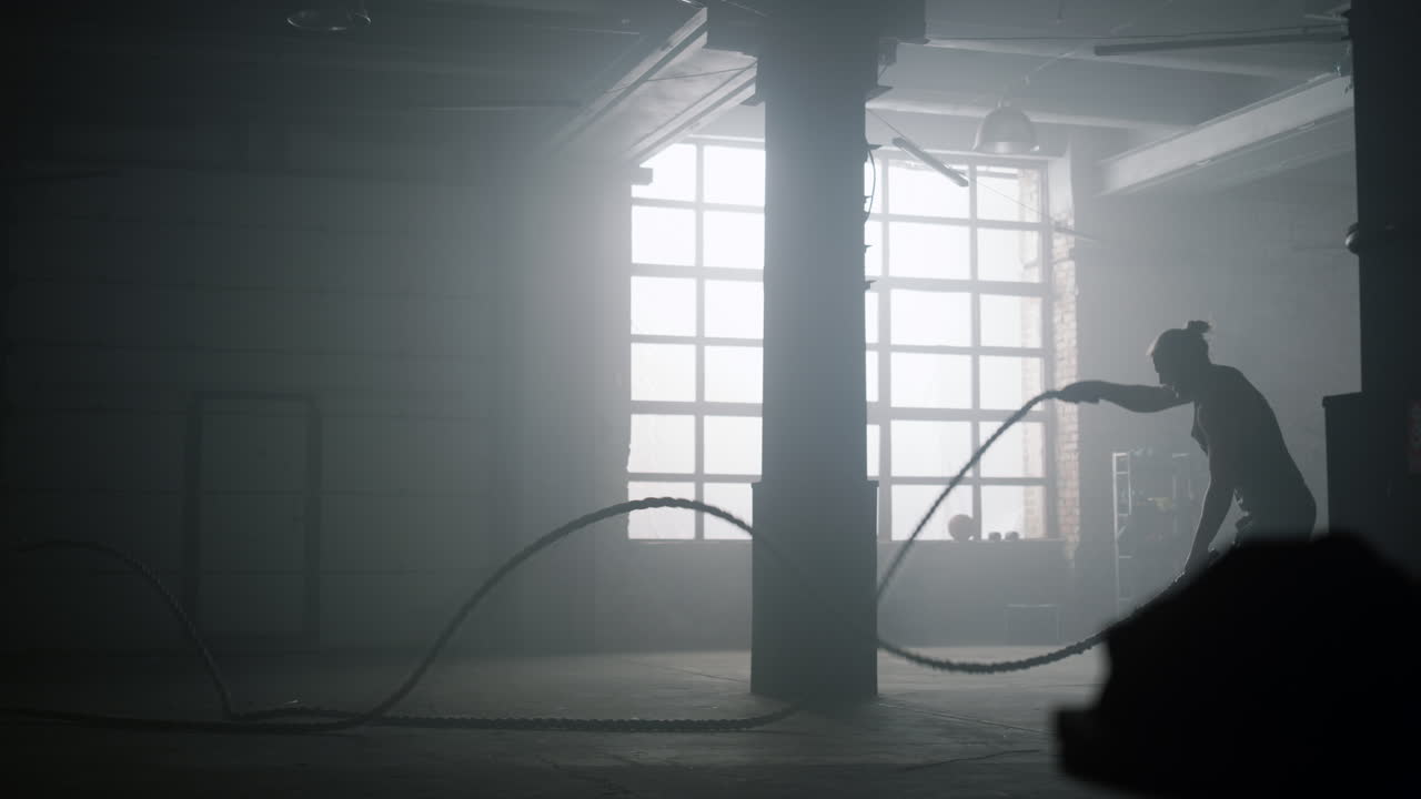 체육관 에서 운동 할 때 전투 로프 를 사용하는 사람. 크로스피트 운동 을 하는 운동 선수