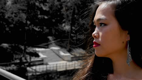 Elegant-woman-in-profile-with-red-lipstick-at-Vienna-Stadtpark,-sunlight,-outdoor,-selective-color