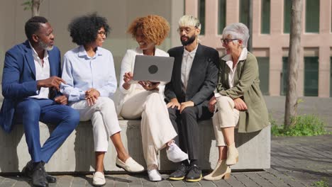 diverse group of business people sitting and collaborating outdoors