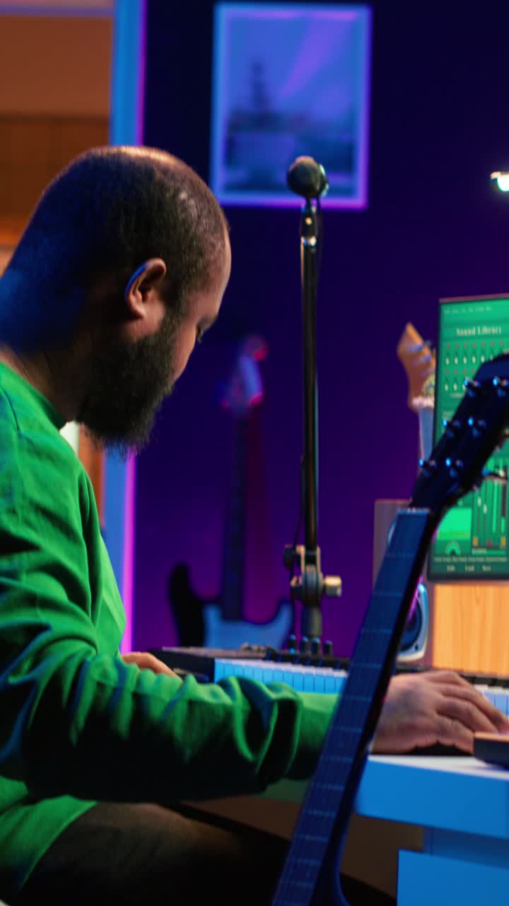 African American Man Playing Keyboard and Guitar in Music Studio