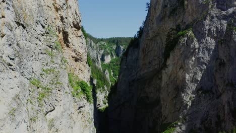 A-fly-through-view-of-a-mountain-range-with-the-blue-sky-and-green-views-ahead