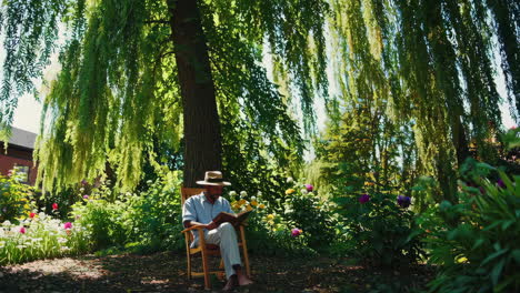man reading a book in a peaceful garden