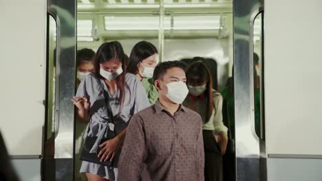 crowd of people wearing face mask on a crowded public subway train travel