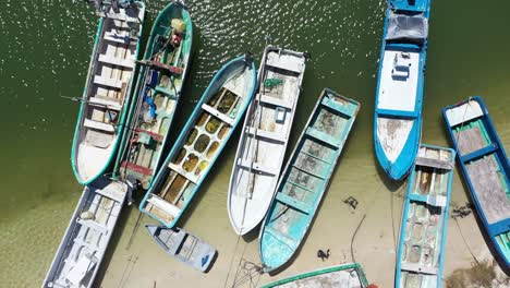 Vista-Aérea-Mirando-Directamente-Hacia-Abajo-Y-Una-Cámara-Que-Muestra-Pequeños-Barcos-De-Pesca-De-Madera-En-Un-Puerto-En-México