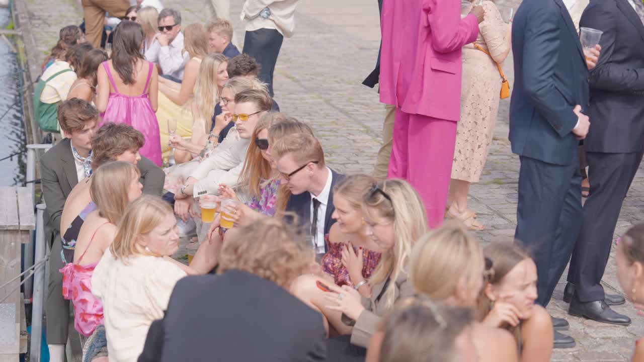 People sit on dock at Reffen street food market cultural event, Copenhagen