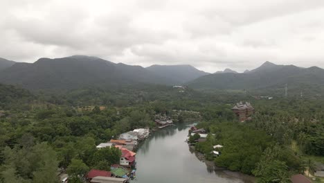 Aerial-view-of-river-and-mountainous-scenery,-tilt-up-approach-shot