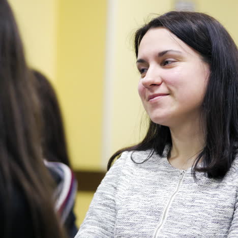 audience in conference hall. young woman is sitting in conference hall and listens attentively the lecture. girl is smiling during the interesting seminar.