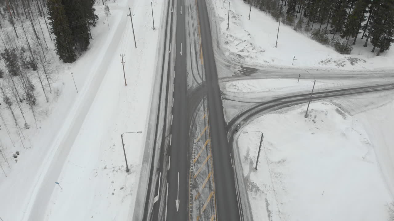 공중, 아래로 기울이기, 드론 샷, 도로 6의 교통량 이상, 눈이 내리지 않는 나무로 둘러싸여, 교차로에서 우회전 및 좌회전하는 자동차, 흐린 겨울날, kontionlahti, 북 카렐리야, 핀란드