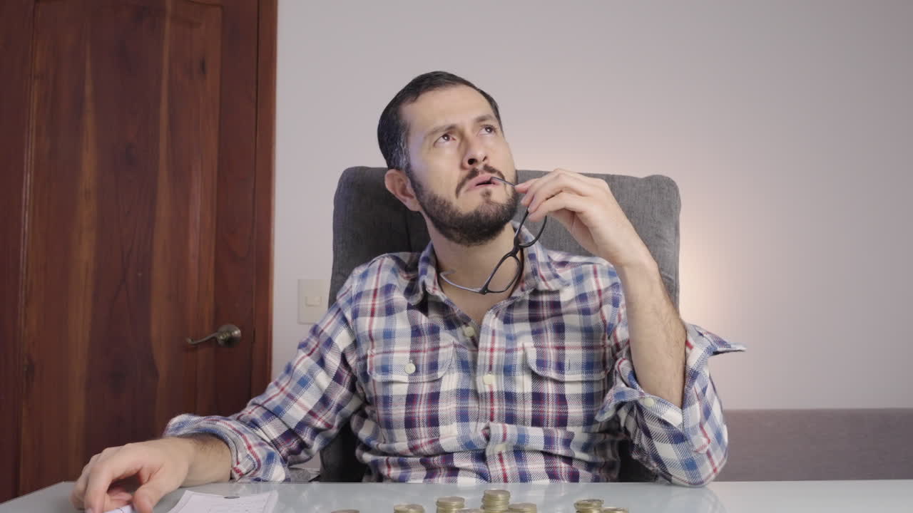 el hombre de negocios se quita las gafas y se las pone en la boca mientras piensa.