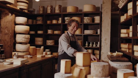 a cheesemonger in a traditional cheese shop surrounded by wheels of cheese