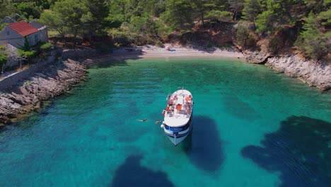 Aerial-of-boat-at-coast-Croatian-island-Hvar,-clear-blue-sea-summer