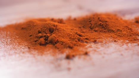 close spinner shot of turmeric piled on a wooden surface spinning from the left