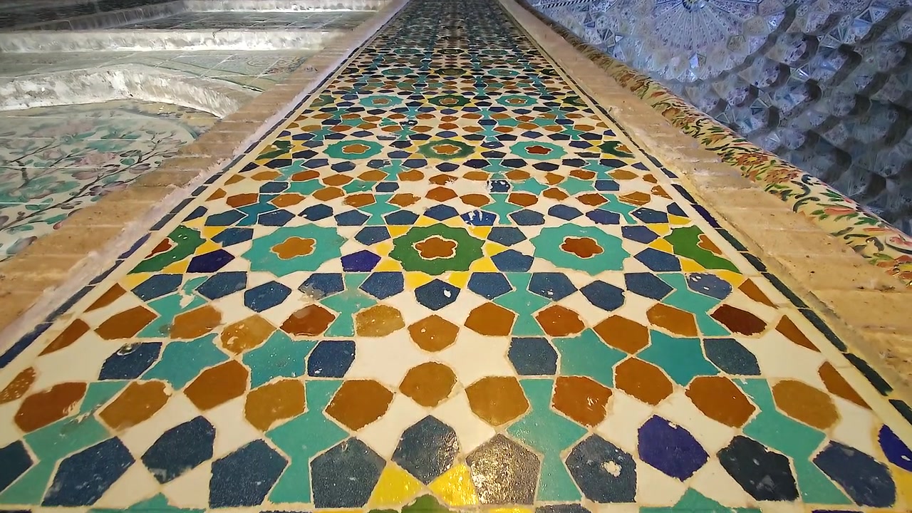 Intricati motivi geometrici di piastrelle su architettura persiana storica.