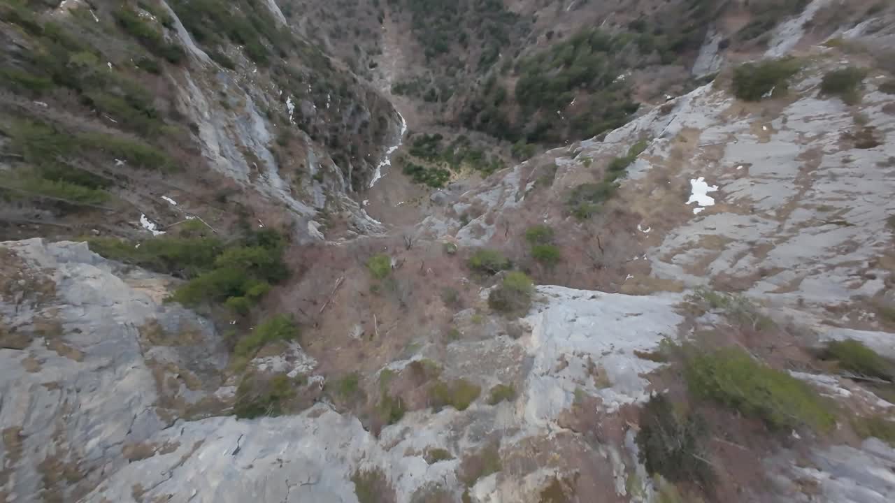 Snow-covered mountains on cloudy day in Switzerland. Walensee Lake during foggy day. FPV curve drone flight. Downhill flight.