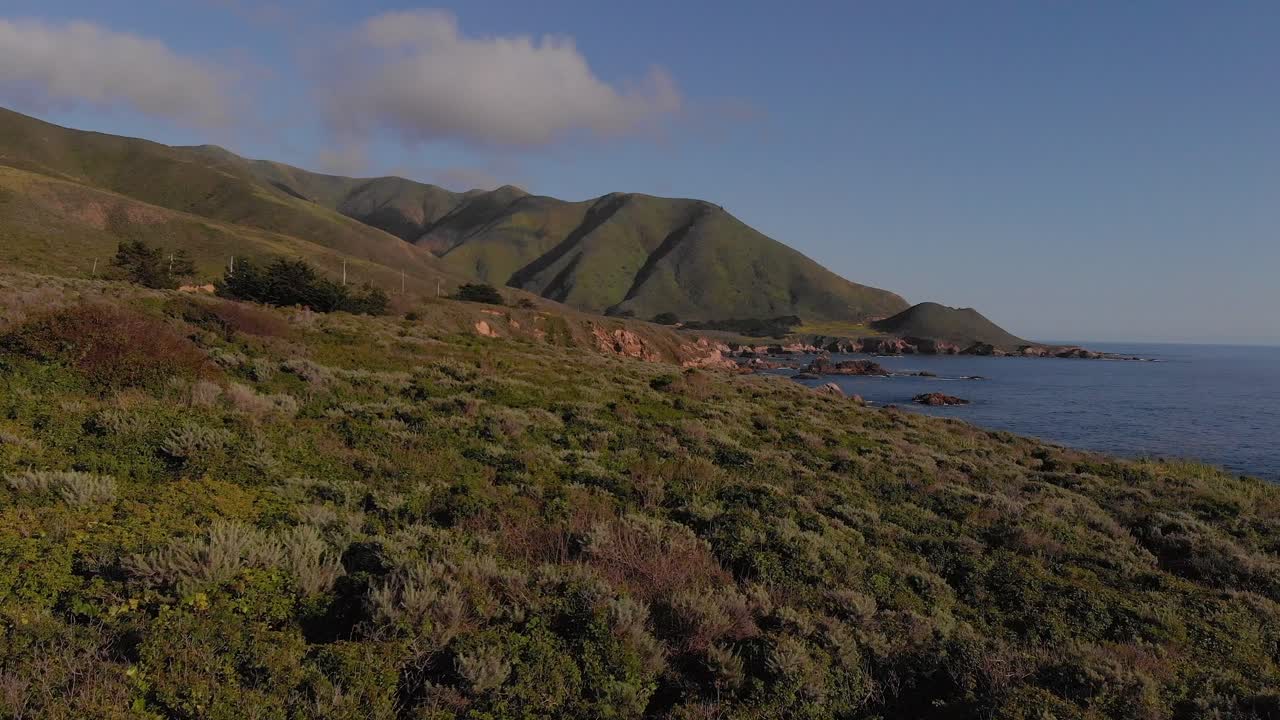 volar sobre la ladera cubierta de hierba junto al océano pacífico, cerca de big sur y carmel, california