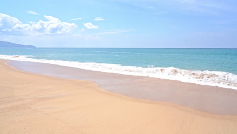 empty island white sand beach and emerald tranquil sea foamy waves rolling on beach, cloudy sky, vacation template, copy space minimalistic