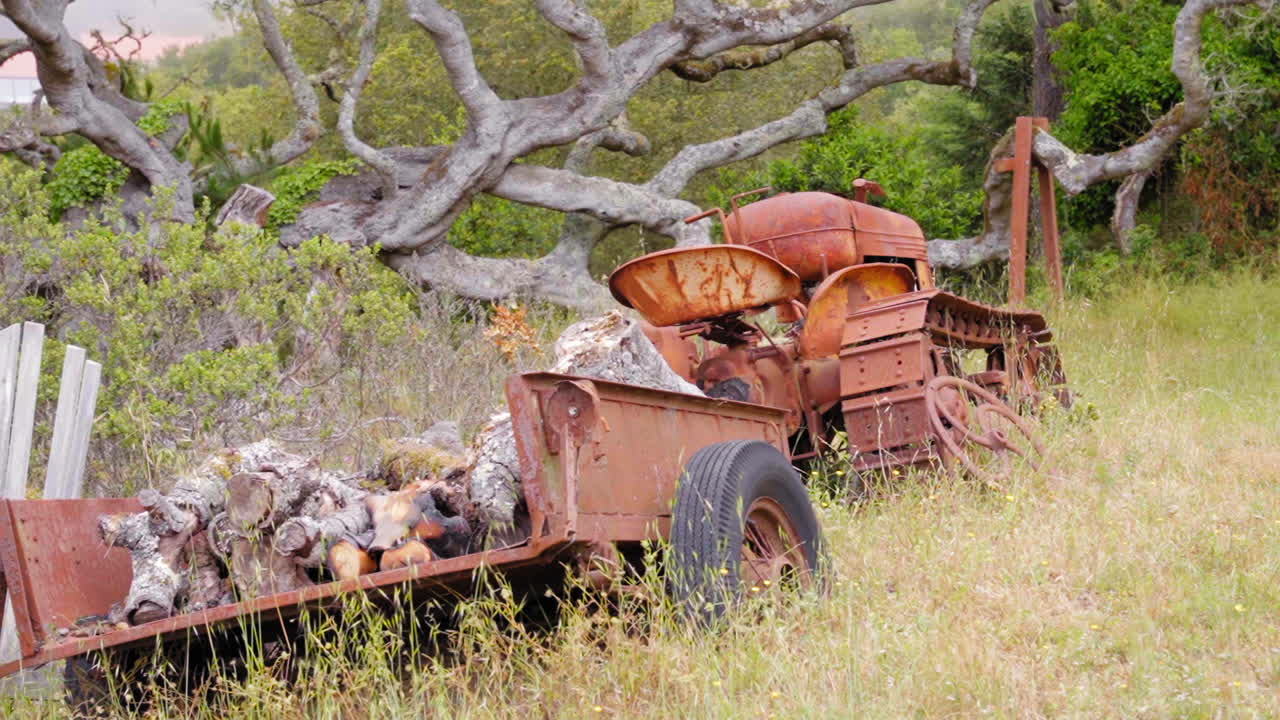 Un trattore e un rimorchio d'epoca arrugginiti, dimenticati e abbandonati nella campagna californiana