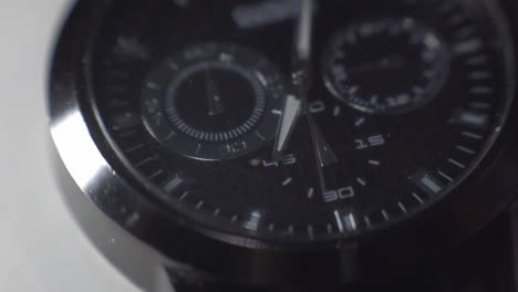 foco que pasa a través del cristal del reloj de un hombre con la mano haciendo tictac - cerrar