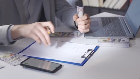 male hand counts money and calculate with calculator.