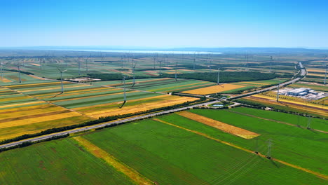 picturesque countryside with green and yellow fields. multiple wind turbines are scattered by the scenery