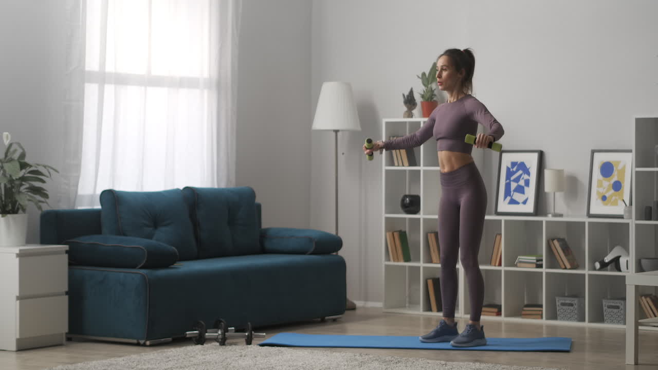 mujer de gimnasio conejo está entrenando en casa con pesas manteniendo buena forma mujer delgada vestida con ropa deportiva estilo de vida saludable de las mujeres modernas