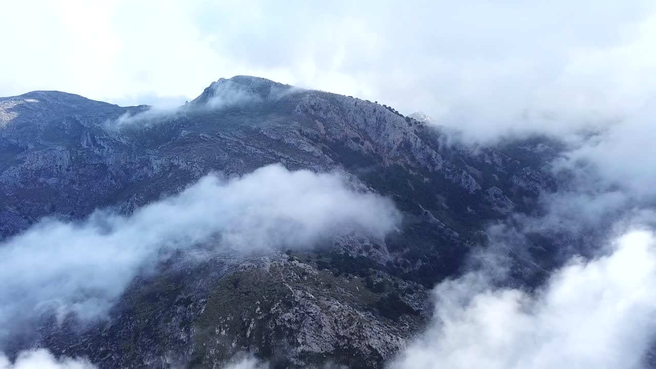 Aerial view through the clouds above Puig Gros summit, Mallorca, Spain