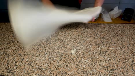 baker skillfully stretches dough to make a middle east pastry or stuffed dough dish