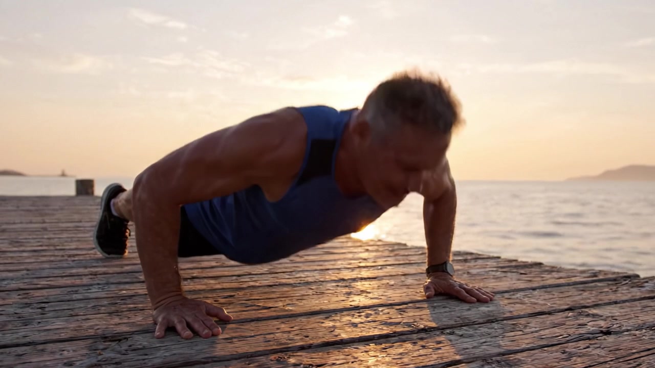 A Determined Individual Engaging in Push-Up Exercises at Sunset on a Pier, Combining Fitness and the Serenity of Nature for a Healthy Lifestyle.