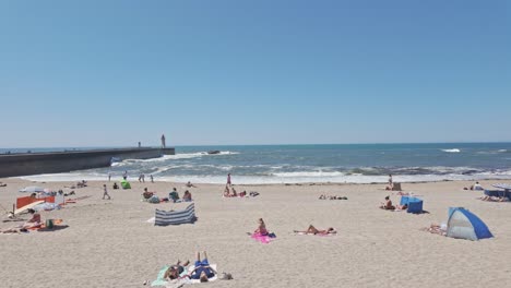 people walk along praia do carneiro beach promenade on a sunny day in porto
