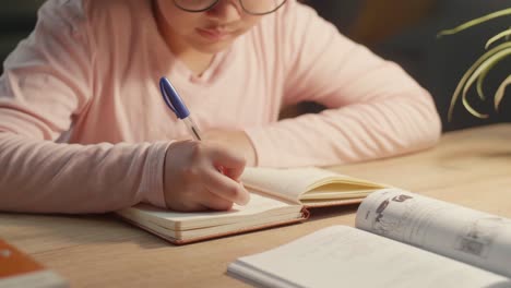 asian child doing homework at night, asia child writing on book