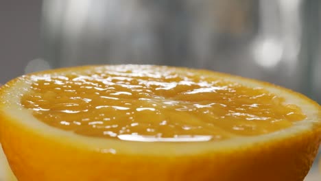 macro shot of orange juice falling on fresh orange slice, super slow motion