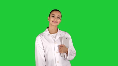 mujer caminando con la tableta en las manos en una pantalla verde, clave de croma