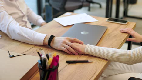 las manos de los compañeros de trabajo en la oficina