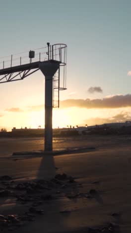 puesta de sol sobre una playa desierta con una torre de observación