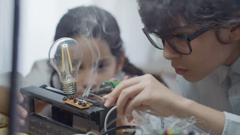 dos niños inteligentes practicando su hobby en ingeniería eléctrica