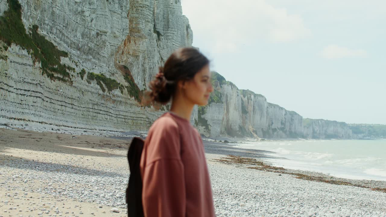 mujer en una playa con acantilados