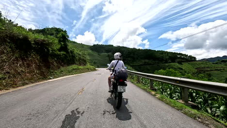 woman riding a scooter along the mountain through ha giang loop in vietnam. - pov shot