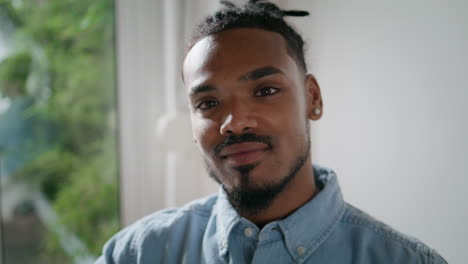 Smiling-man-posing-camera-home-alone-closeup.-Freelancer-face-looking-indoors